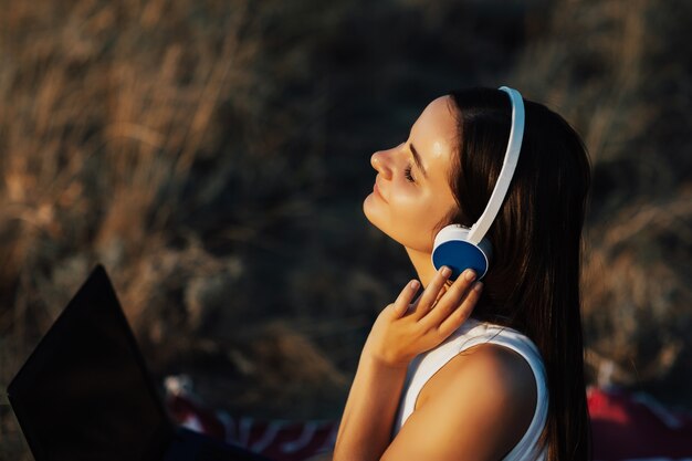 Chica joven con auriculares está escuchando música y disfruta