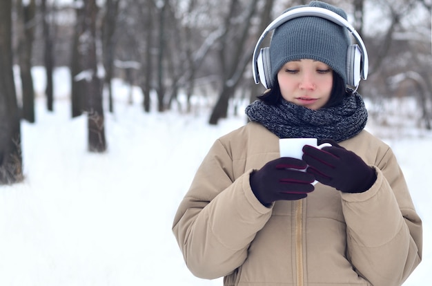 Chica joven con auriculares y taza de café