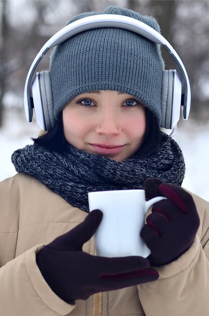 Chica joven con auriculares y taza de café