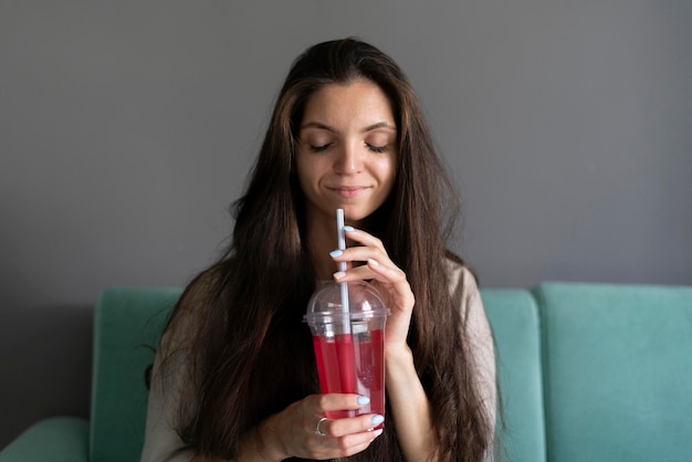 Una chica joven bebiendo un cóctel fresco