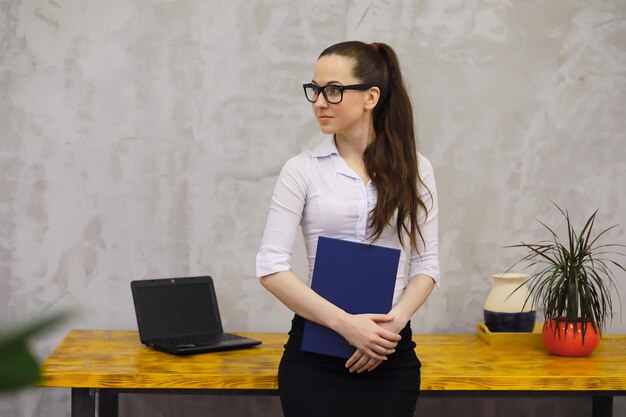 Chica joven y bella en ropa casual. El estudiante se prepara para la sesión.