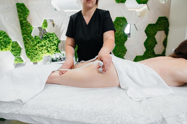 Una chica joven y bonita está disfrutando de un masaje al vacío profesional en el Spa. Cuidado del cuerpo. Salón de belleza.