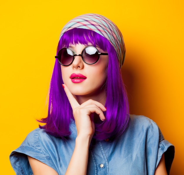 Chica joven con cabello morado y gafas de sol en amarillo