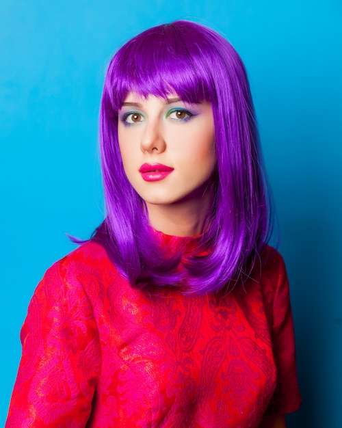 Foto chica joven con cabello morado y vestido rojo sobre azul