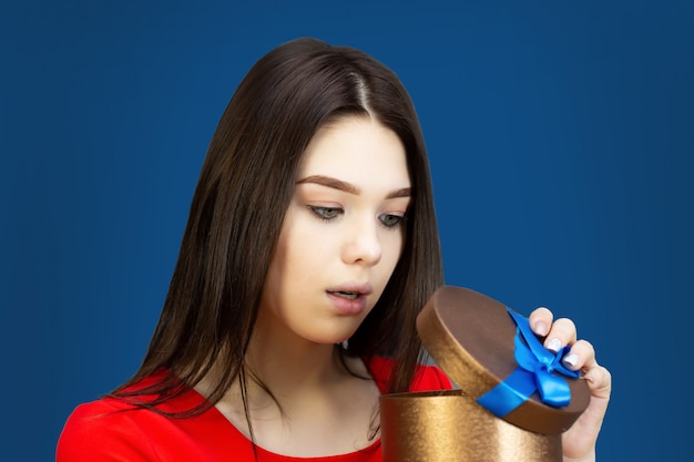 Chica joven con una caja de regalo con lazo azul