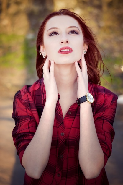 Chica joven en una camisa a cuadros roja