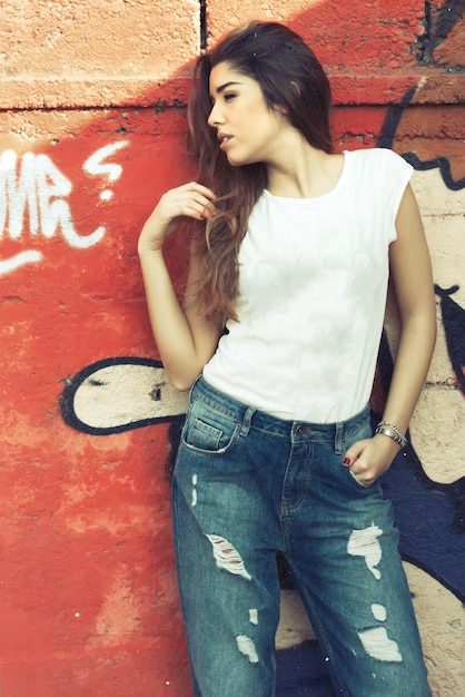 Foto chica joven con camiseta blanca frente a murales