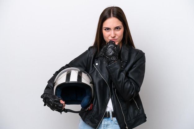 Chica joven con un casco de motocicleta aislado sobre fondo blanco que tiene dudas