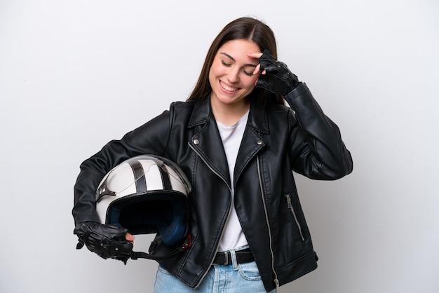 Chica joven con un casco de motocicleta aislado sobre fondo blanco riendo
