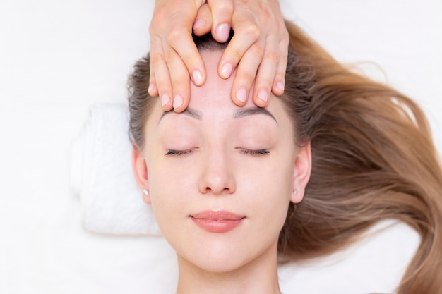 Chica joven con cejas gruesas y piel perfecta en el fondo blanco, concepto de foto de belleza, cuidado de la piel, concepto de spa, tratamiento, masaje facial