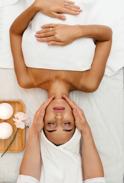 Chica joven con cejas gruesas y piel perfecta en el fondo blanco.