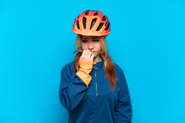 Chica joven ciclista aislado sobre fondo azul con dudas