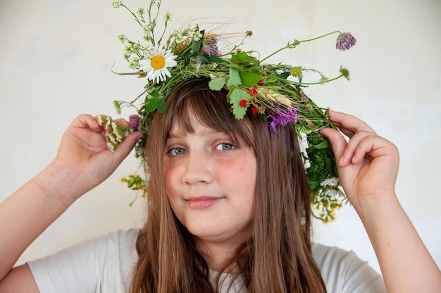 Chica joven en corona de flores silvestres