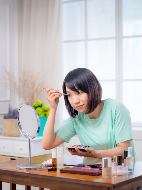 Chica joven con cosméticos de maquillaje