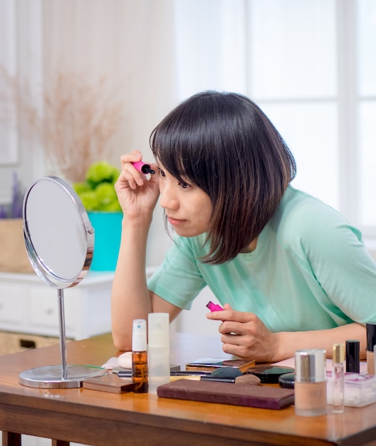 Chica joven con cosméticos de maquillaje