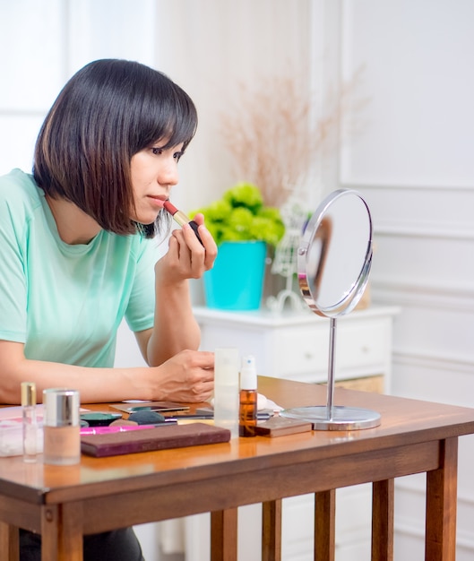 Chica joven con cosméticos de maquillaje