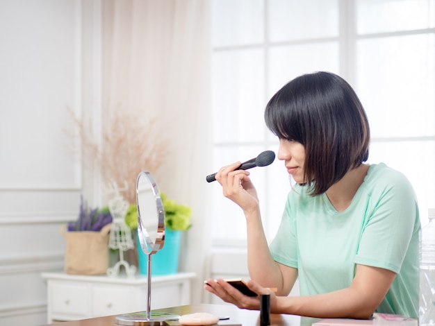 Chica joven con cosméticos de maquillaje