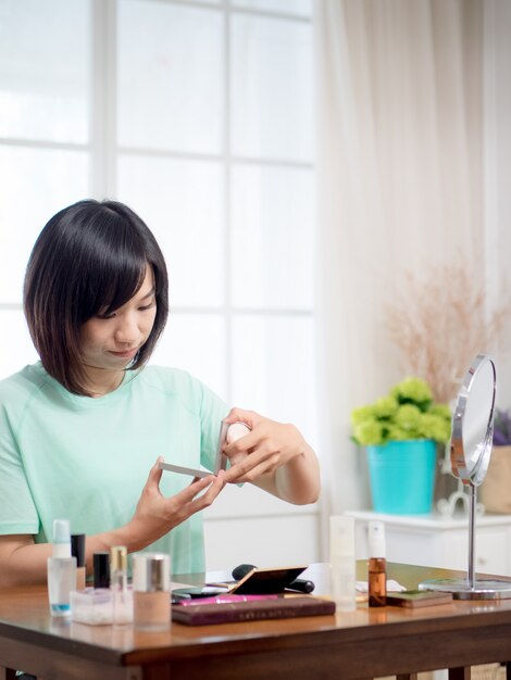 Chica joven con cosméticos de maquillaje