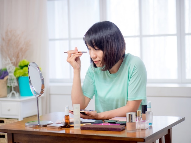 Chica joven con cosméticos de maquillaje