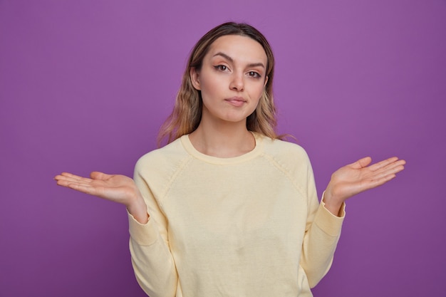 Chica joven despistada mostrando las manos vacías