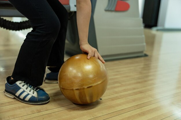 Foto una chica joven divirtiéndose con la pelota en el club de bolos.