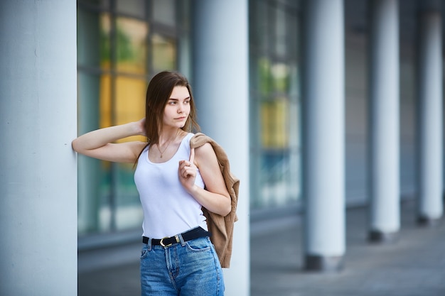 Chica joven se encuentra cerca del edificio. Copia espacio