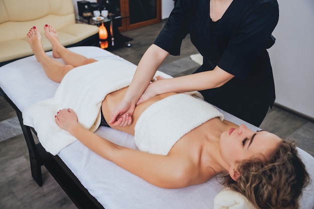 Chica joven es relajante en el spa.