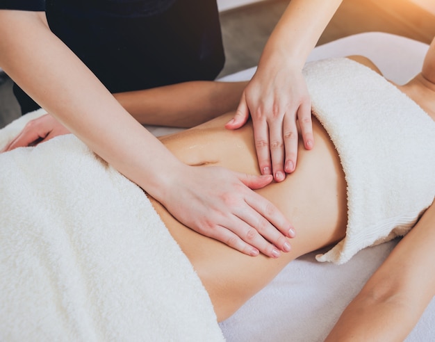 Chica joven es relajante en el spa.