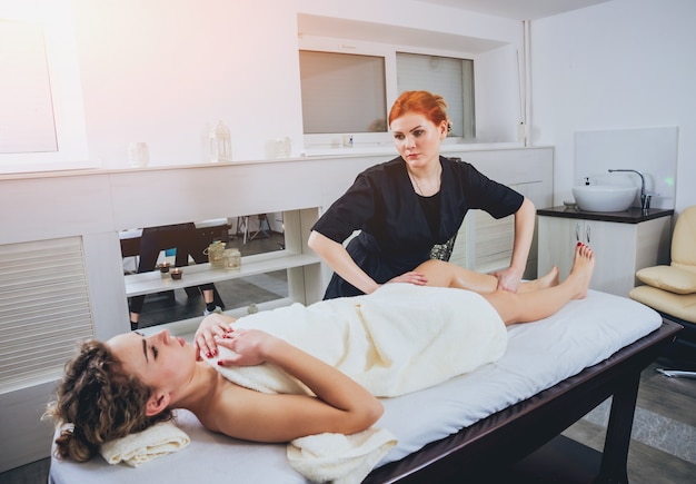 Chica joven es relajante en el spa.