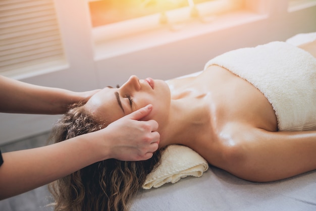 Chica joven es relajante en el spa.