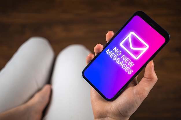 Chica joven espera un nuevo mensaje Pantalla del teléfono inteligente sin notificación de mensajes nuevos Primer plano Comunicación y foto del concepto de chat
