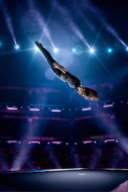 La chica joven está saltando en el trampolín