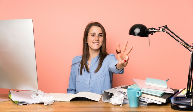 Chica joven estudiante feliz y contando tres con los dedos