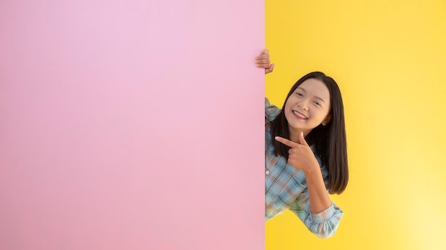 Chica joven estudiante feliz con fondo rosa y amarillo.