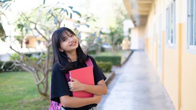 Chica joven estudiante feliz con mochila en la escuela