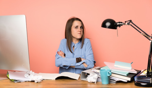 Chica joven estudiante haciendo gesto de dudas mientras levanta los hombros