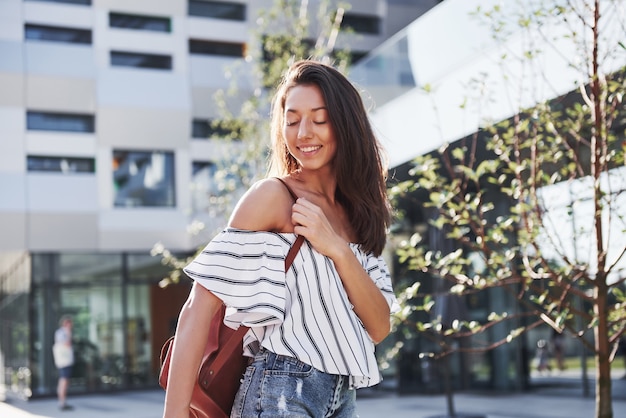 Chica joven estudiante hermosa, feliz con mochila cerca del campus de la Universidad. Concepto de educación y ocio.