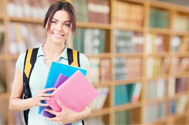 Chica joven estudiante con mochila y libros