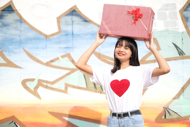 Chica joven feliz con caja de regalo