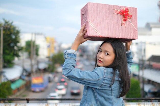 Chica joven feliz con caja de regalo