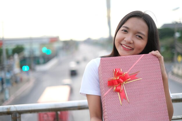 Chica joven feliz con caja de regalo