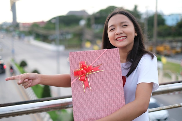 Chica joven feliz con caja de regalo