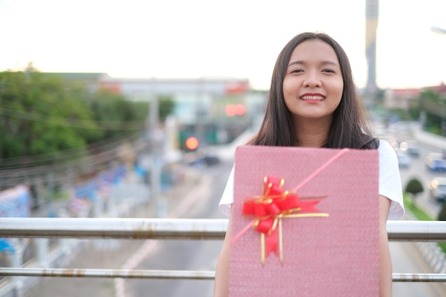 Chica joven feliz con caja de regalo