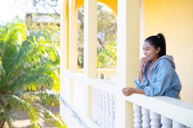 Foto chica joven feliz de pie en la construcción de fondo amarillo