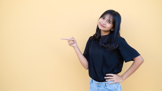 Chica joven feliz usar camisa negra sobre fondo naranja