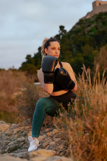 Chica joven en forma con guantes de boxeo al aire libre