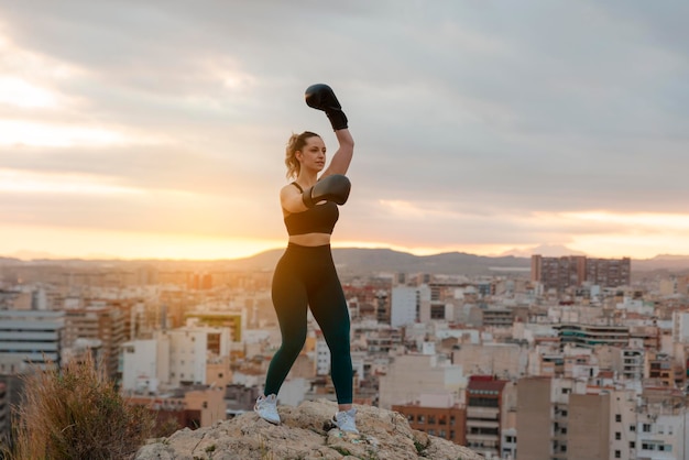 Chica joven en forma con guantes de boxeo al aire libre