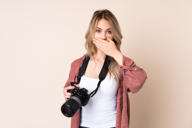 Chica joven fotógrafo sobre aislado cubriendo la boca con las manos