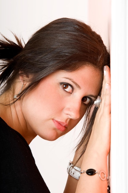 Foto chica joven frente a la pared mirando a la cámara