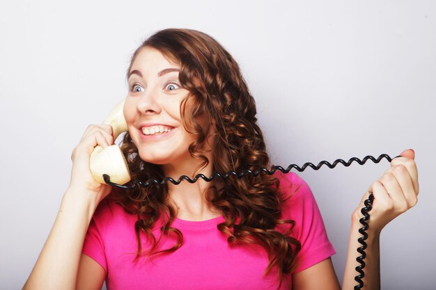 Foto chica joven furiosa con teléfono vintage